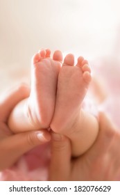 Mother holding a little pink baby feet - Shutterstock ID 182076629