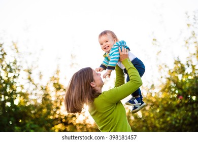 Mother Holding Little Son, Throwing Him In The Air