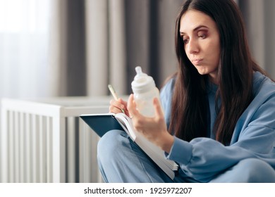 Mother Holding Milk Bottle Keeping a Baby Food Journal. Responsible mom writing a feeding diary concerned with appetite

