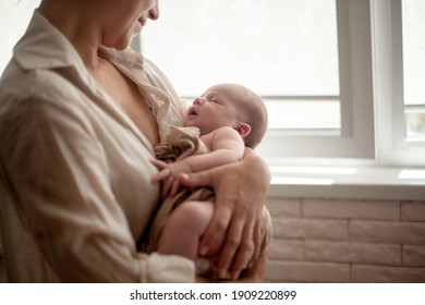 Mother holding newborn baby and breastfeedidiing little infant kid in hands 