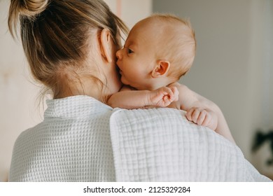 Mother holding newborn baby on shoulder, with a burping cloth. - Shutterstock ID 2125329284