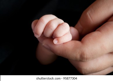 Mother Holding Newborn Baby's Hand