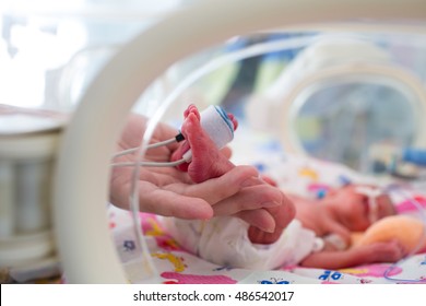 Mother Holding Premature Baby Legs With Neonatal Infant Pulse Oximeter 