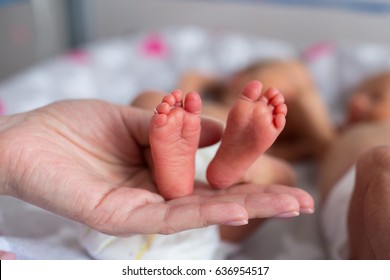 mother holding premature baby legs