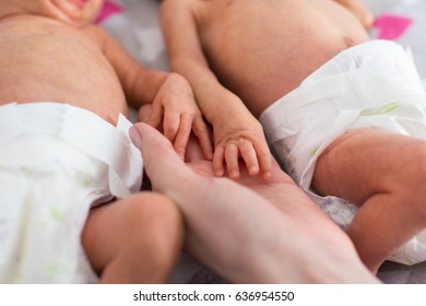 Mother Holding Premature Twins Hands