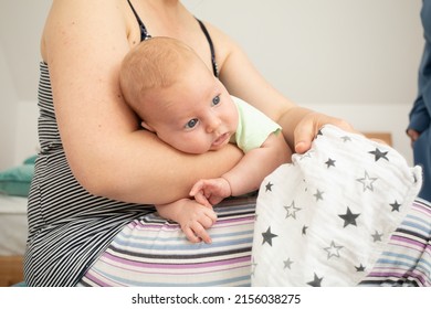 Mother holding and rocking baby sitting on fitball