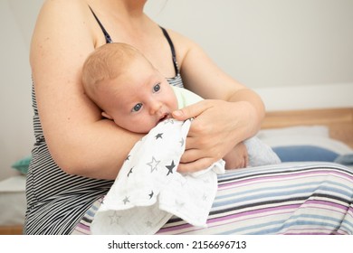 Mother holding and rocking baby sitting on fitball