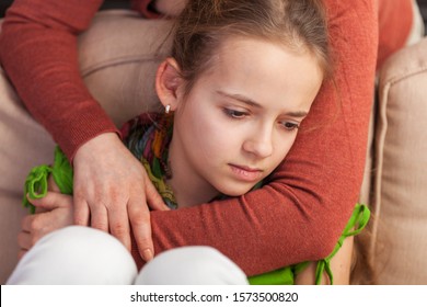 Mother Holding Sad Teenager Girl From Behind Trying To Provide Comfort And Support In A Dire Situation - Close Up