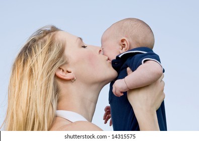 Mother Holding Son Up Kissing Him On Cheek