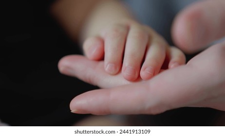 mother holds the hand of newborn. children hand. hospital takes care of happy family medicine concept. newborn baby holding mom hand close-up. mom takes care close-up baby in the hospital - Powered by Shutterstock