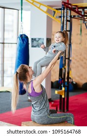 Mother holds her daughter in her arms in the gym - Shutterstock ID 1095164768