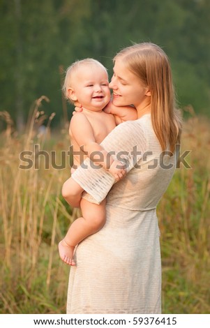 mother holds smiling baby girl on hands