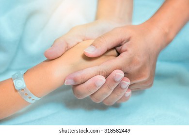 Mother holing boy patient's hands and comforting her