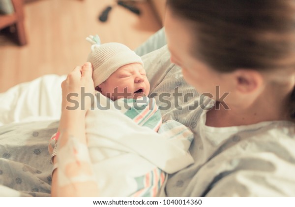 Mother in hospital holding her new born baby boy. Birth and new life. 