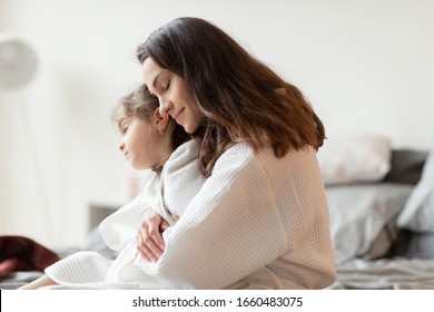 Mother Hugging From Back Loving Sleepy Daughter. Little Girl Frozen After Shower. Bedroom Design Interior. Bedtime And Night Dream Nap. Child Care And Attention. Adorable Family Portrait