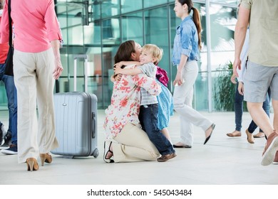 Mother hugging children at airport - Powered by Shutterstock