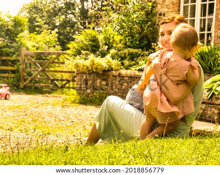 Mother hugging her son and baby daughter in a beautiful summer holidays cottage in the United Kingdom