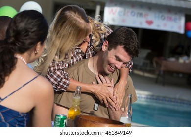 Mother Hugging Mid Adult Soldier Son At Homecoming Party