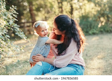 Mother Hugging Pacifying Sad Upset Stressed Crying Toddler Girl. Family Young Mom And Crying Baby In Park Outdoor. Bonding Attachment Relationship Of Mom And Child Baby. Family Together Protection