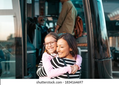 A mother hugs her daughter in front of the bus before her trip. - Powered by Shutterstock