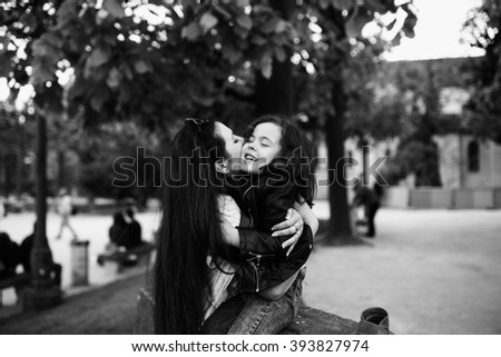 Two lesbian colombian women embracing and smiling in a park with greenery