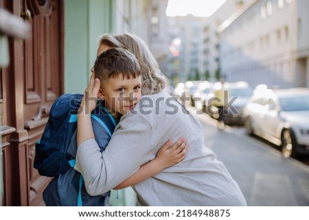 Mother hugs her young son on the way to school, and a mother and boy say goodbye before school.