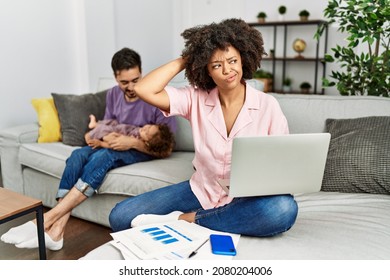 Mother Of Interracial Family Working Using Computer Laptop At Home Confuse And Wondering About Question. Uncertain With Doubt, Thinking With Hand On Head. Pensive Concept. 