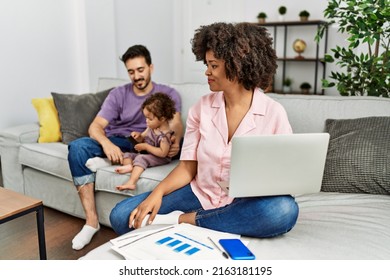 Mother Of Interracial Family Working Using Computer Laptop At Home Looking To Side, Relax Profile Pose With Natural Face And Confident Smile. 