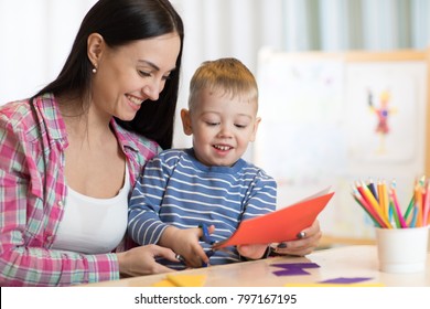 Mother with kid boy fun cut scissors colored paper