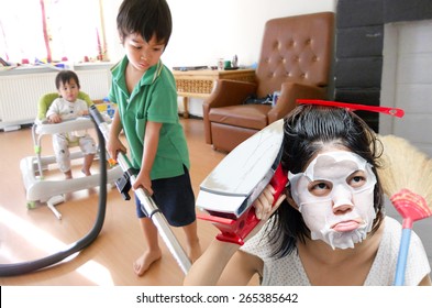 Mother With Kid Cleaning House With Boring Face In A House