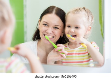 Mother And KId Daughter Brushing Teeth Together