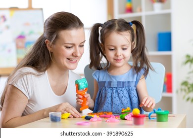 Mother and kid daughter at home molded from clay and play together. Concept of preschool or home education. - Powered by Shutterstock