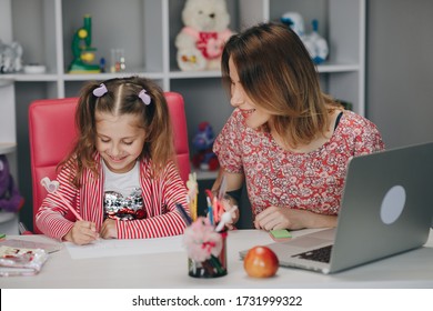 Mutter und Kind zu Hause machen Hausaufgaben online. Fernstudium online. Mama macht Hausaufgaben mit ihrer Tochter zu Hause.