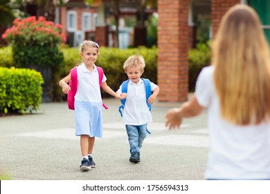 Mother And Kids After School. Young Mom Picking Up Children After Lessons In Kindergarten Or Preschool. Pick Up Students. Boy And Girl Running To Parents In School Yard.