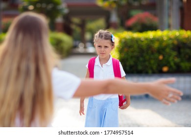 Mother And Kids After School. Young Mom Picking Up Children After Lessons In Kindergarten Or Preschool. Pick Up Students. Boy And Girl Running To Parents In School Yard.