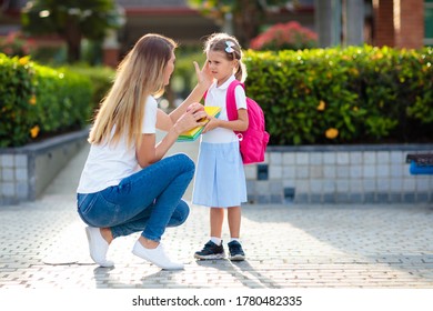 Mother And Kids After School. Young Mom Picking Up Children After Lessons In Kindergarten Or Preschool. Pick Up Students. Boy And Girl Running To Parents In School Yard.