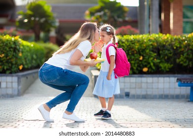 Mother And Kids After School. Young Mom Picking Up Children After Lessons In Kindergarten Or Preschool. Pick Up Students. Boy And Girl Running To Parents In School Yard.