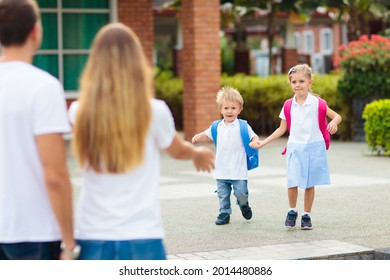 Mother And Kids After School. Young Mom Picking Up Children After Lessons In Kindergarten Or Preschool. Pick Up Students. Boy And Girl Running To Parents In School Yard.