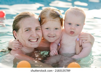 Mother And Kids Having Fun In The Swimming Pool. Summer Leisure And Family Holidays And Vacation Concept. People Swim In A Metal Frame Pool In The Backyard. Mom With Children: Baby Son And Daughter.