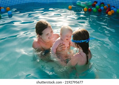 Mother And Kids Having Fun In The Swimming Pool. Summer Leisure And Family Holidays And Vacation Concept. People Swim In A Metal Frame Pool In The Backyard. Mom With Children: Baby Son And Daughter.