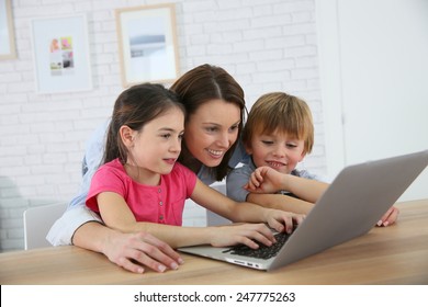 Mother With Kids Playing On Laptop Computer