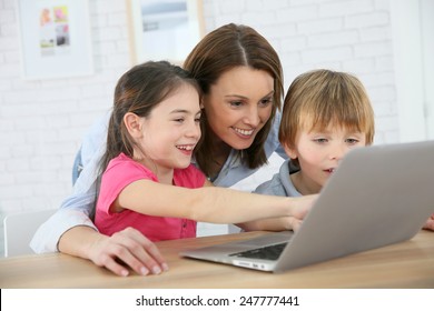 Mother With Kids Playing On Laptop Computer