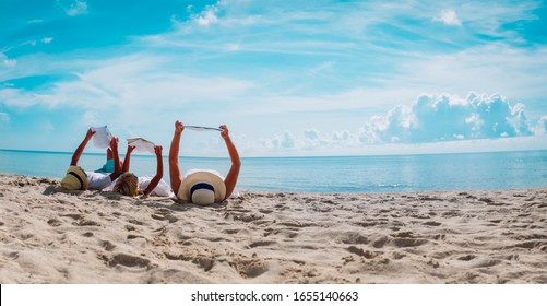 Mother With Kids Reading Books At Beach, Family On Vacation