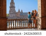 Mother with kids in Sevilla look at magnificent plaza de Espana in sunset light during their hot summer vacations in Spain