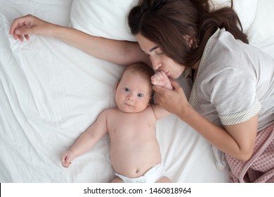 The Mother Kisses The Baby . The Brunette Lies With A Blind Child. Top View