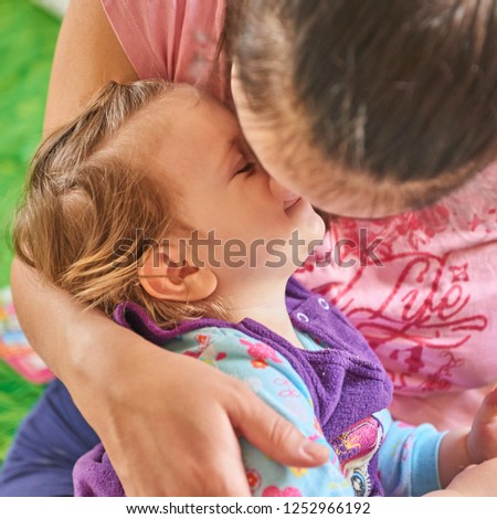Mother kisses her little two yearsold daughter