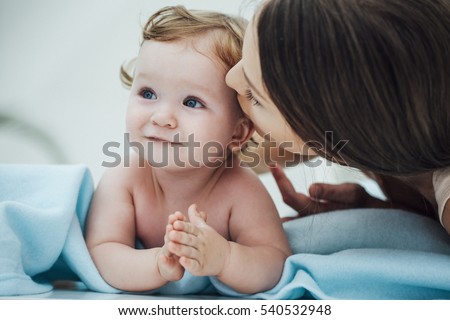 Mother Kissing Baby in Bed