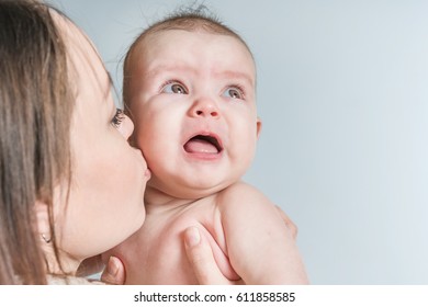 Mother Kissing Crying Baby