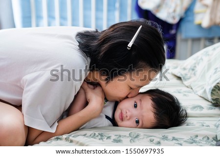 a mother kissing her baby on his cheek