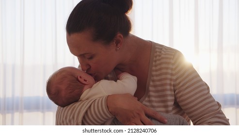 Mother Kissing Her Son. Close Up Shot Of A Loving Mothers Kiss.  Young Mom Kissing Beautiful And Healthy Baby's Cheek. Mum Cares Of Her Infant Baby. Baby Stare. 
